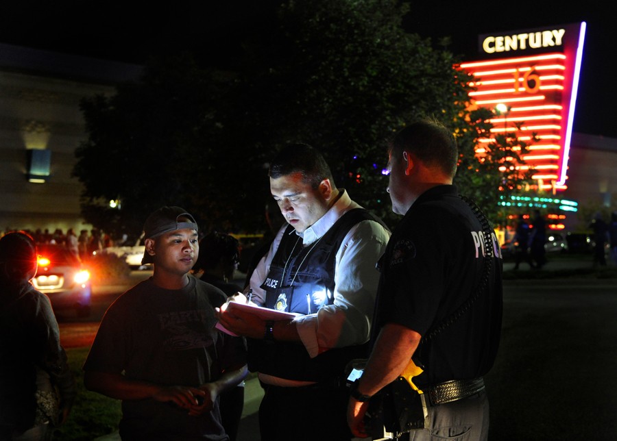 An Aurora Police Department detective takes a witness statement following a mass shooting on July 20, 2012. (Karl Gehring - July 23, 2012)