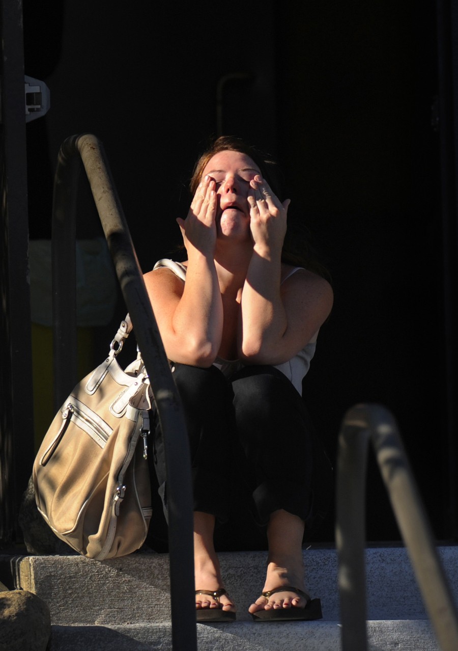 Amanda Medek wipes her tears outside Gateway High School while searching for her sister. (RJ Sangosti - July 21, 2012)