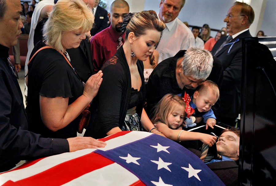 Chantel Blunk, center, says good-bye to her husband, Jonathan Blunk, surrounded by family and friends and her two children, Maximus Blunk, 2, and Hailey Blunk, 4, on Friday, August 3, 2012, during a full military funeral at Mountain View Mortuary in Reno, Nevada. (RJ Sangosti - August 3, 2012)</i>