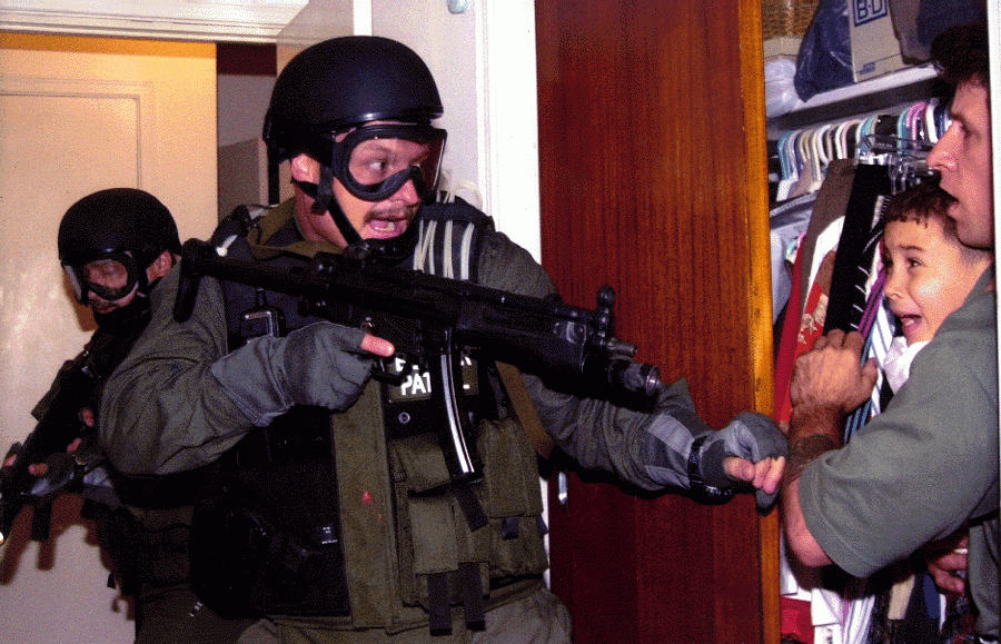 Cuban refugee Elian Gonzalez and Donato Dalrymple, one of the two men who rescued the boy from the sea, in a bedroom closet as federal agents enter the Little Havana home of Elian's relatives. 