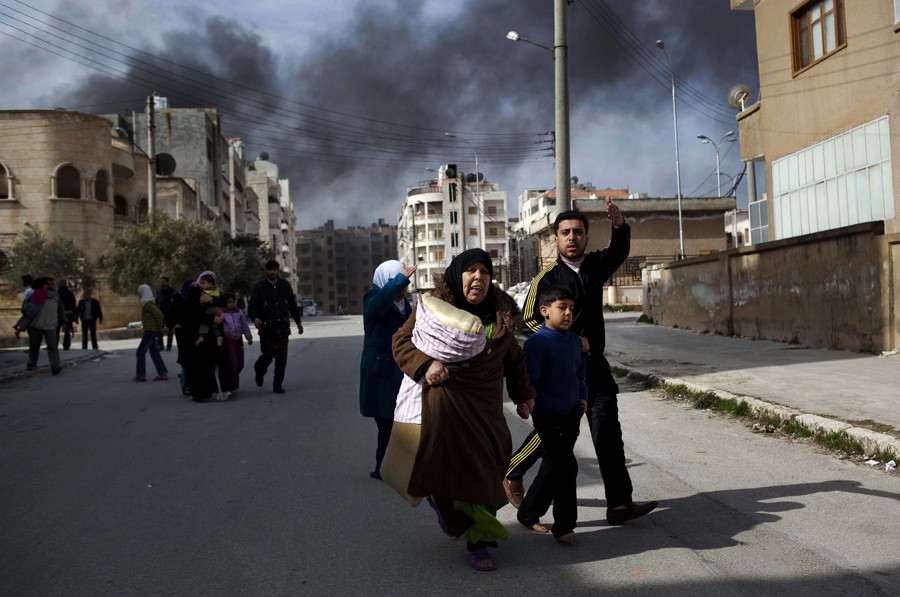 A family escapes from fierce fighting between Free Syrian Army fighters and government troops in Idlib, northern Syria, March 10, 2012. (Rodrigo Abd, Associated Press - March 10, 2012)