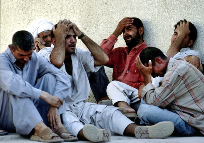 Baqouba - At a hospital morgue, relatives mourn the death of Iraqi national guardsman Ryaad Khudayar, one of at least four guardsmen killed in a car bombing at a checkpoint outside Baqouba. 