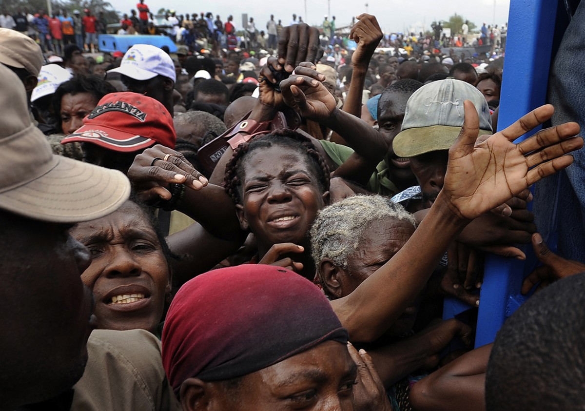 'Desperation'  Frantic survivors fight to get in the gate at a food distribution center in Cite Soleil, a slum plagued by poverty even before the earthquake destroyed the area’s fragile infrastructure. The United States and other countries rushed emergency stocks of aid and supplies to Haiti. Like doctors working on a dying patient, foreign governments labored to establish a kind of life-support system that would bring Haiti back. (Carol Guzy, The Washington Post - January 26, 2010)